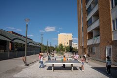 Barn spelar pingis på ett torg.