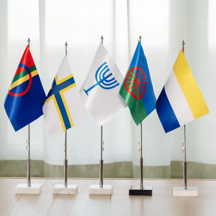 De nationella minoriteternas flaggor står på ett bord