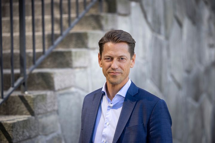 Magnus Jägerskog, generaldirektör MUCF, står vänd mot kameran med en stentrappa i bakgrunden iförd ljusblå skjorta och mörkblå kavaj.