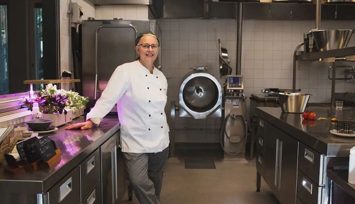 Anna-Karin Ris står iklädd kockkläder i sitt kök på Almarevägens förskola.