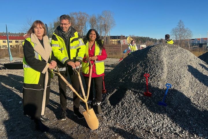 Eva Ullberg, Jonas Granström och Emma Feldman står med en tredelad spade intill en jordhög.