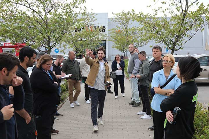 En grupp människor står utomhus på en handelsplats under en gemensam trygghetsvandring.