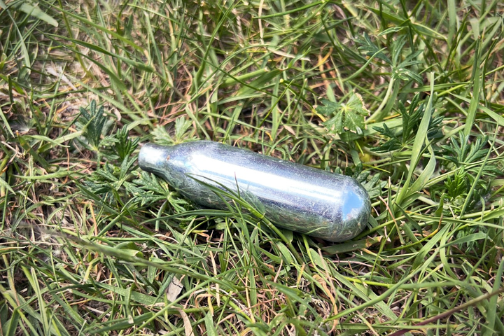 Lustgaspatron slängd i gräset