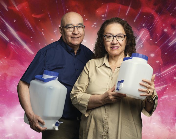 En man och en kvinna står och håller var sin vattendunk.