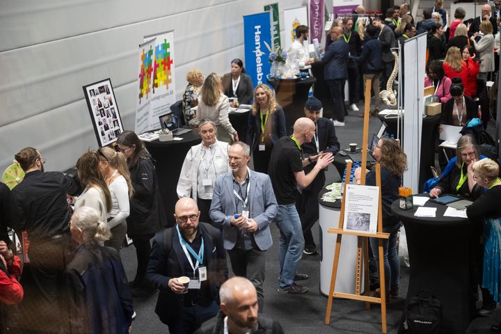 Besökare samlas vid olika utställningsbås på en mässa.
