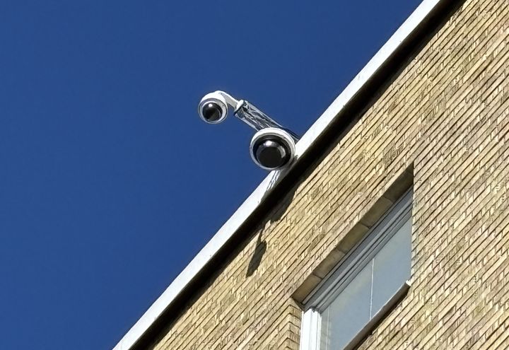 Kamera monterad på taget på ett flerfamiljshus.