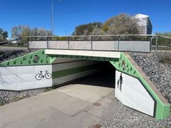 Gång- och cykeltunnel med grön dekor och symboler för cykel och gående.