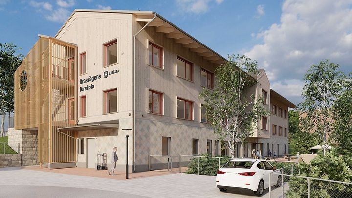 Exteriör av en modern förskolebyggnad med flera våningar. En bil står parkerad framför.