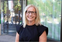 Karin Nilsson, blond och klädd i svart, står framför Järfällas kommunhus.