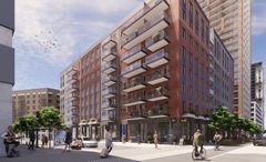 Vy över ett modernt bostadskvarter med flera våningar, cyklister och fotgängare i förgrunden.