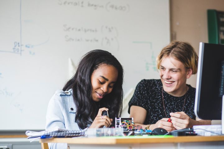 Två studenter bygger en elektronisk krets vid ett bord.