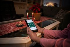 En person sitter i ett rum och håller en mobiltelefon som visar kontaktsidan för Jourhavande präst.