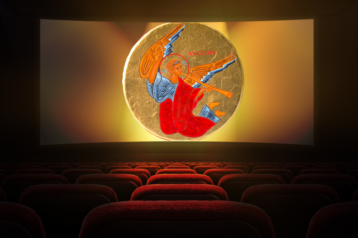 “Angelos statuette with vibrant angel design on display in dimly lit theater.”