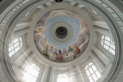 Takmålning i en kyrka föreställande människor runt ett bord i gemenskap.