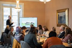 Ett möte hålls i ett konferensrum med flera personer som lyssnar på en presentation om djurskydd.