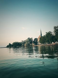 Vadstena klosterkyrka speglar sig i Vättern. Det är populärt bland pilgrimer att svalka sig med ett dopp efter framkomst.