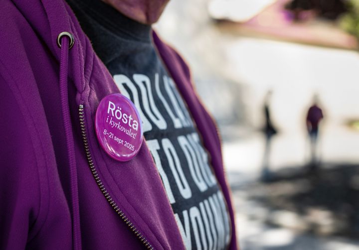 Knappnål i förgrunden som säger att det man ska rösta i kyrkovalet 8-21 september