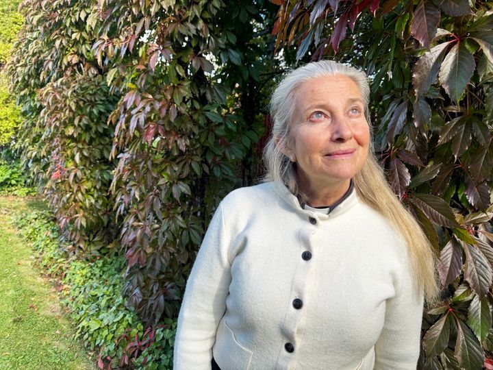 Aneby pastorats ny kyrkoherde Moa Sjögren framför en buske med höstfärger