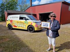 Birgitta bredvid en ID. Buzz Cargo på familjen Wemmerts gård i skånska Hyllinge - 75 år efter Sveriges första folkabuss levererats på samma plats.