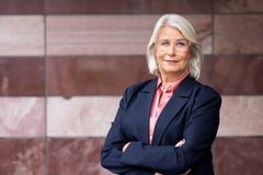 Victoria Kirchhoff, 1:e vice förbundsordförande Unionen. Hon har en blå kostym, rosa skjorta och står framför en rosa stenvägg.