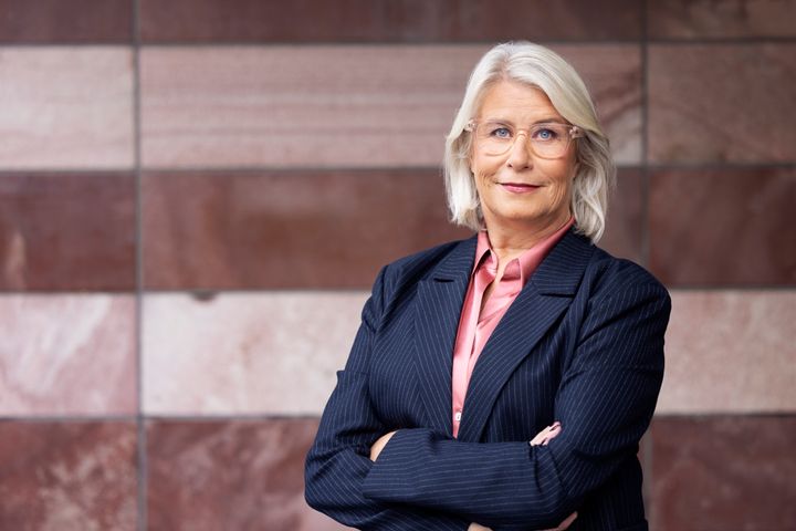 Victoria Kirchhoff, 1:e vice förbundsordförande Unionen. Hon har en blå kostym, rosa skjorta och står framför en rosa stenvägg.