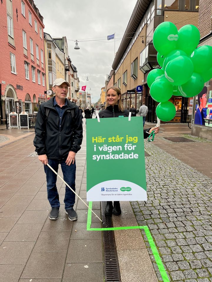 Tomas Wallèn, ordförande SRF Uppsala och Jenny Svensson, Specsavers Uppsala gjorde gemensam sak och drog en grön linje för att uppmärksamma SRF:s Synlinjen som hjälper synskadade att ta sig an hinder i vardagen.