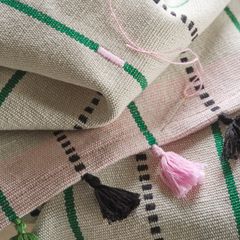 Vävd löpare med gröna och svarta ränder samt rosa och svarta tofsar.