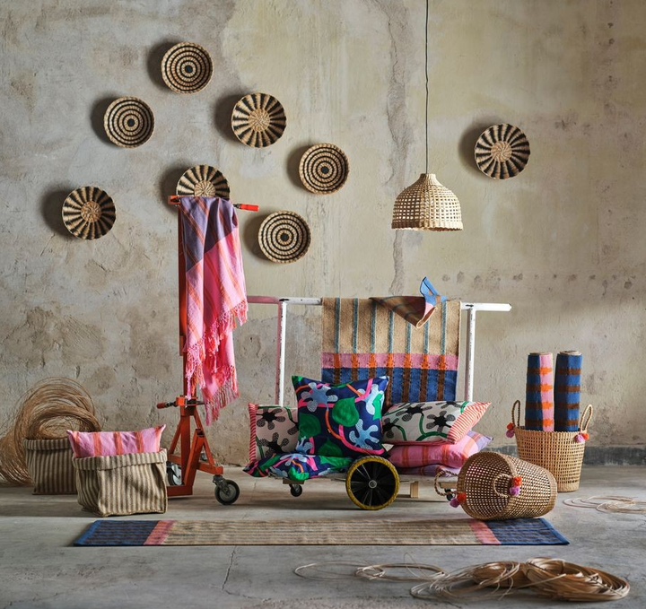 En%20rustik%20inredning%20med%20f%E4rgglada%20textilier%20och%20korgar%20p%E5%20golvet%2C%20med%20dekorativa%20fl%E4tade%20tallrikar%20p%E5%20v%E4ggen.