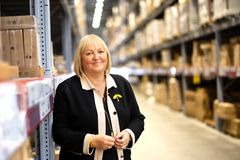 En kvinna i svart kavaj står i en gång i ett tag själv-lager i ett IKEA-varuhus.