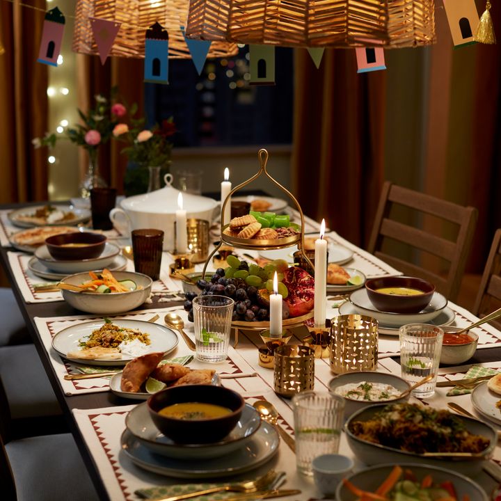 Ett festligt dukat middagsbord med olika rätter, tända ljus och dekorationer.