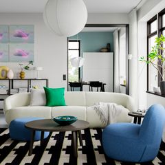 Modernt vardagsrum med en vit soffa, grön kudde och blå fåtölj. Svartvitt geometriskt mönstrad matta på golvet.