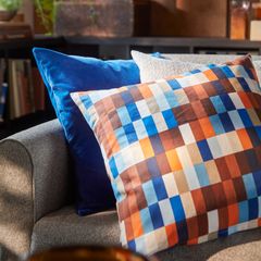 Färgglada kuddar på en soffa i ett vardagsrum.