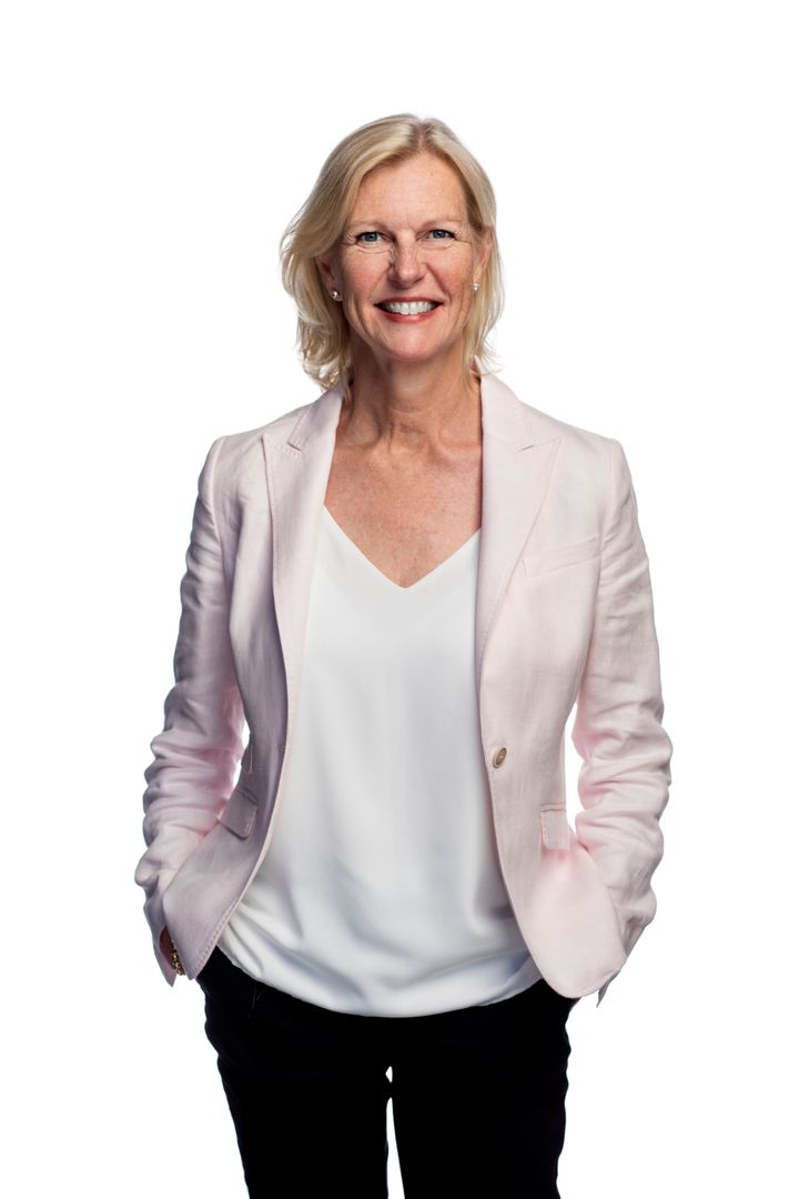 Ulla Gutsafsson står leende med ljus kavaj och vit blus står mot en vit bakgrund.