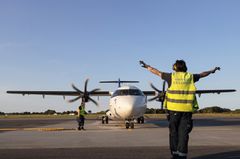 Alt text: "SAS ATR 72 flygplan taxar på Kalmar Öland Airport, en markpersonal i gul väst dirigerar planet."