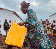 Tillgång till rent vatten är ett av de humanitära behov som behöver tillgodoses och delas ut till behövande, som här till kvinnan som bor i Lushagala Extension och Bushagara internflyktingläger utanför Goma i Nordkivu, DR Kongo.