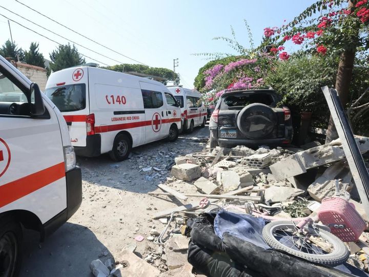 En ambulans från Röda Korset Libanon står bredvid bråte och förstörelse