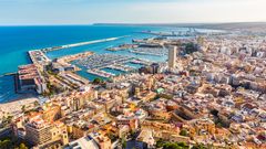 Flygfoto över kuststad i Alicante, Spanien med hamn och höga byggnader.