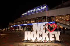 Alt text: "Utsidan av Scandinavium arena på natten med en stor skylt som säger 'WE LOVE HOCKEY' i förgrunden."