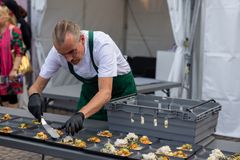 Juryordförande Patrik Sewerin lägger upp smakprov av finalrätterna på engångsfria tallrikar från Light My Fire Borrow till publiken på Kungstorget
