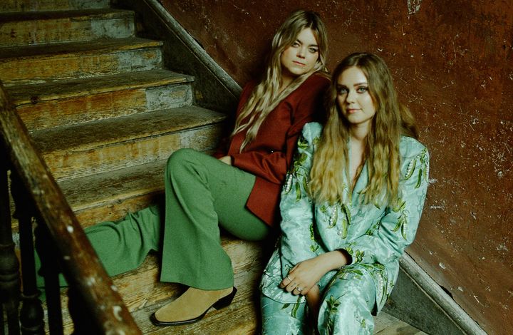 Två kvinnliga musiker sitter i en trappa.