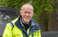 Leende medelålders man i gul och grå varseljacka med Tekniska verkens logga