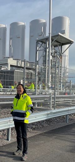 Anna Lövsén, enhetschef Biogas på Tekniska verken, framför de fyra lagringstankarna för infångad biogen koldioxid.