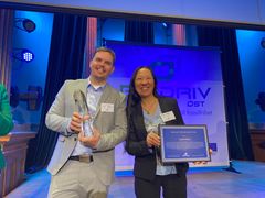 Erik Nordell - korthårig man med ljusgrå kostym - och Anna Lövsén - långhårig kvinna i svart kostym - står bredvid varandra och håller i varsin plakett och tittar leende in i kameran