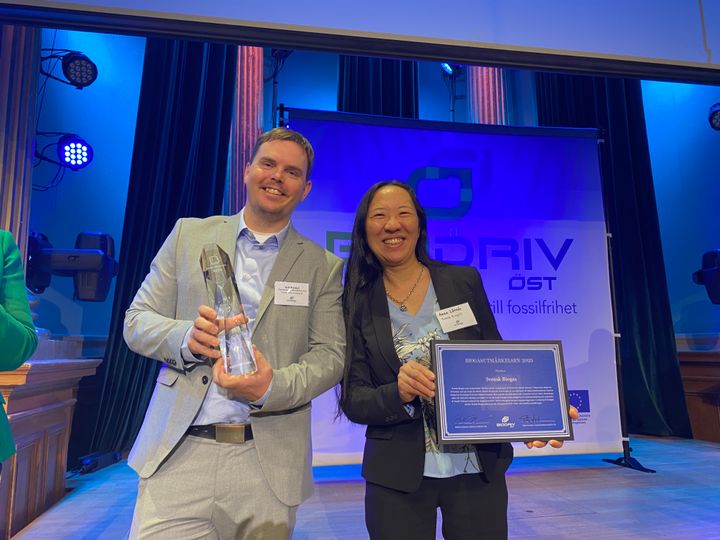 Erik Nordell - korthårig man med ljusgrå kostym - och Anna Lövsén - långhårig kvinna i svart kostym - står bredvid varandra och håller i varsin plakett och tittar leende in i kameran