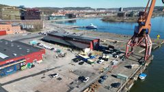 Flygbild av en Lindholmens kajkant med byggnader, en kran, och parkerade bilar. Vatten syns i bakgrunden.
