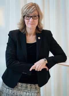 Camilla Frankelius, förhandlingschef vid Sveriges Ingenjörer, står med armarna korsade och leende framför en ljus bakgrund.