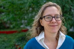 Bild av Andrea Eriksson, professor på KTH, utomhus med grönska i bakgrunden.