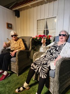 Helga Rämö (t.v) och Tuula Vikberg hälsar välkommen till Solrummet på Hedvigsgården. Ute är mörkt och kallt, men härinne kan de koppla av till solstrålande värme och dagsljus.