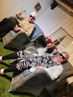 Helga Rämö (t.v) och Tuula Vikberg hälsar välkommen till Solrummet på Hedvigsgården där de bor. Ute är mörkt och kallt, men härinne kan de koppla av till solstrålande värme och dagsljus.