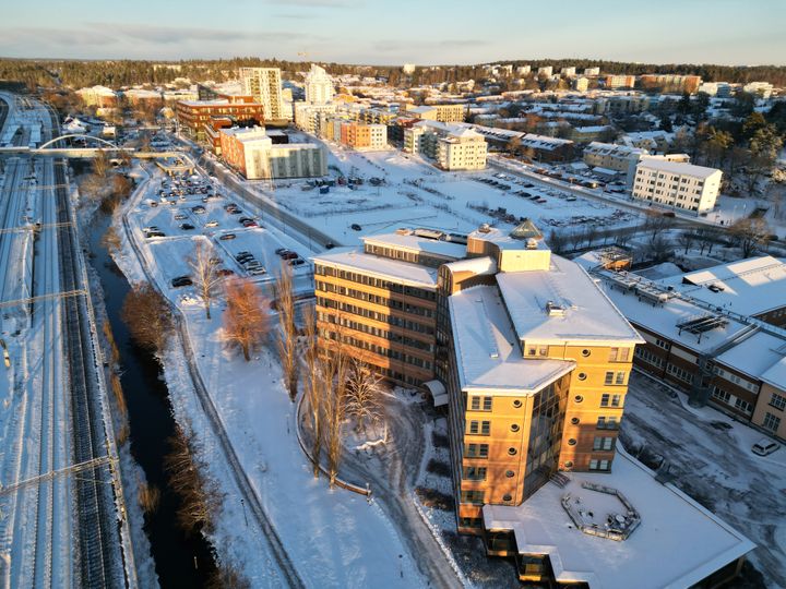 Vy över järnvägsområdet i Väsby med det framtida kommunhuset i förgrunden. Byggnaden är just nu under renovering för att bli arbetsplats för kommunens anställda.